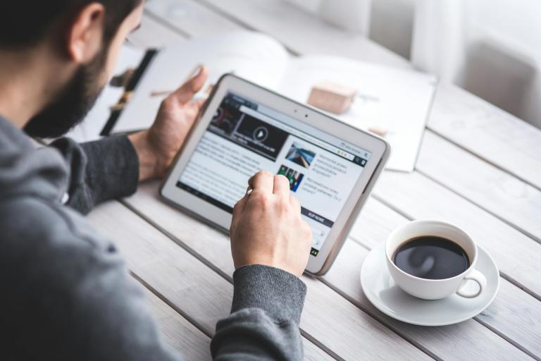 Man reading news on a tablet device